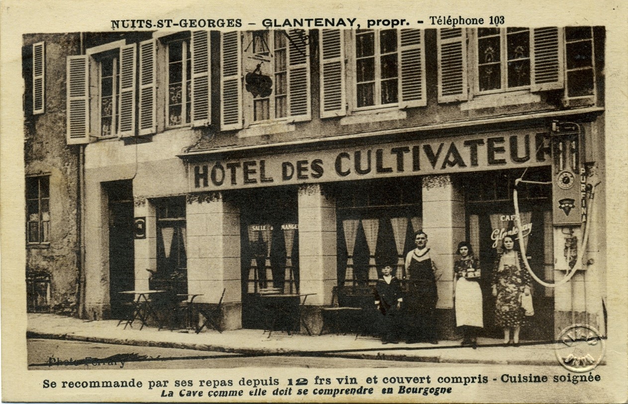 Figure 7 : Carte postale représentant la devanture de l’hôtel des Cultivateurs à Nuits-Saint-Georges (années 1931-1934). A droite, une pompe à essence murale. Source : Musée de la Vie bourguignonne Perrin de Puycousin.